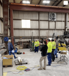 A group of electrical workers gathers to discuss any new technology new types of equipment or changes in procedures that would affect the use of safety related work practices on this particular project